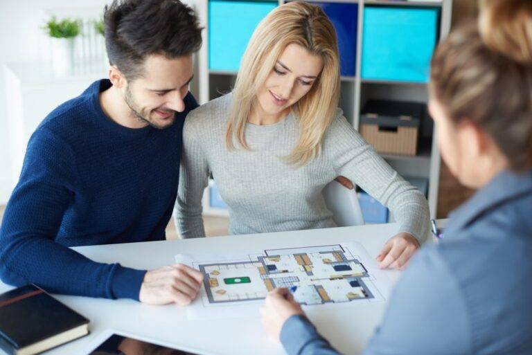 Clients reviewing a property floor plan with a Chughtai Estate Advisor consultant